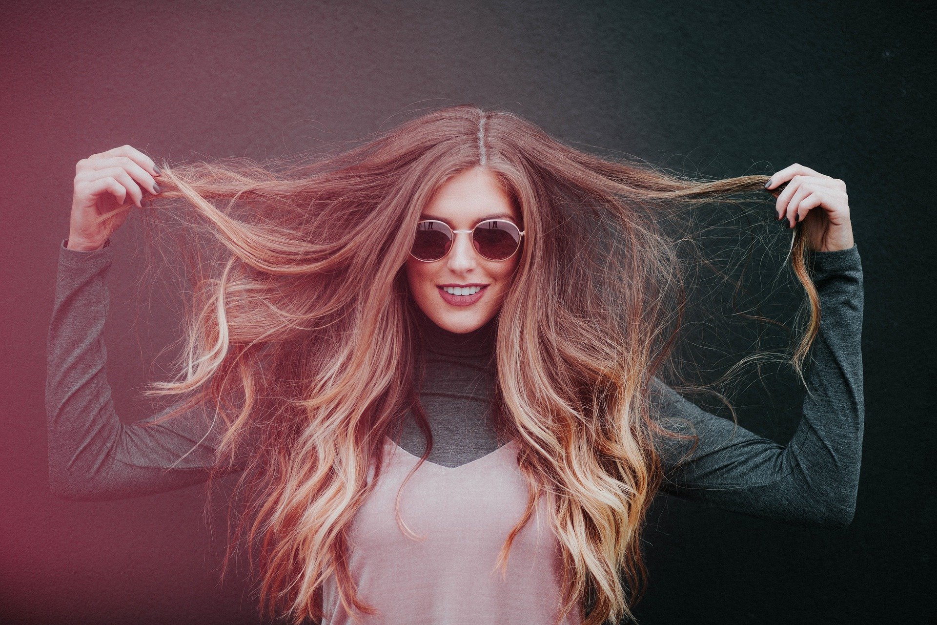 mujer sosteniendo las puntas de su cabello largo