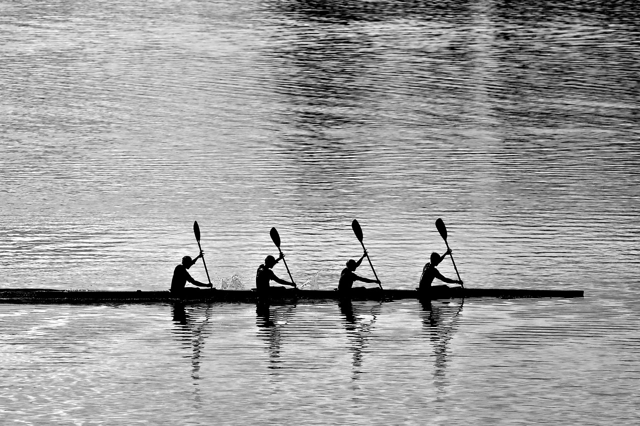 cuatro hombres remando en un lago 