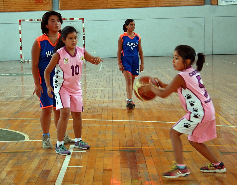 Niñas jugando básquetbol con la indumentaria de sus clubes