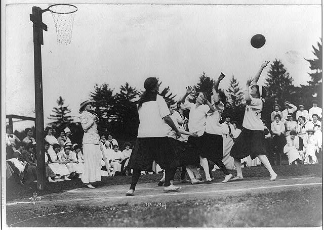foto histórica en blanco y negro en que muestra muchachas jugando básquetbol de pollera y con un aro sin tablero.