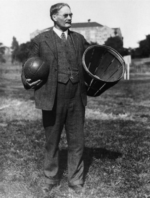 Naismith sosteniendo una cesta de Basketball y una pelota en la otra Imagen histórica en blanco y negro que muestra al creador de este juego deportivo