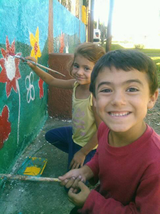 Niños pintando mural