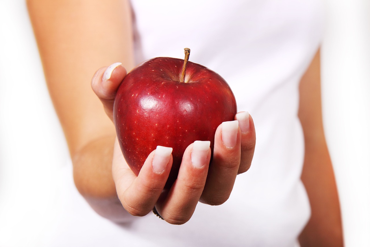 Manzana roja en la mano de una mujer