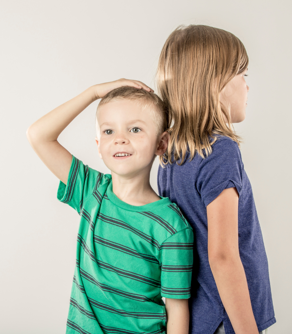 Dos niños de espalda para comparar estaturas