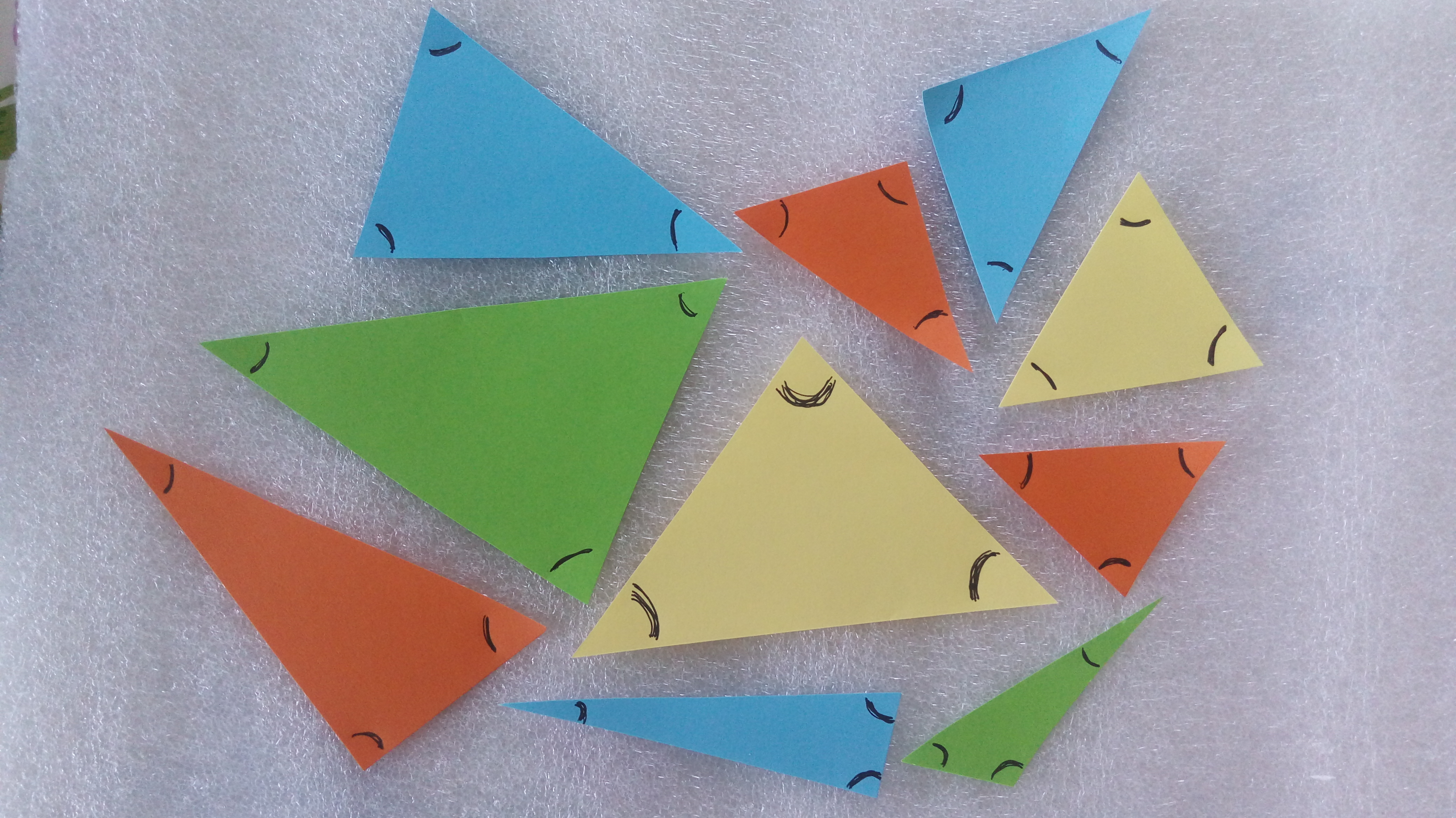 En la imagen aparecen diez triángulos con distintas características en cuanto a la medida de sus lados y sus ángulos (hay triángulos mas "pequeños" y otros más "grandes", algunos tienen ángulos agudos, rectos u obtusos). En cada triángulo se han marcado con un arco con bolígrafo negro, sus tres ángulos.