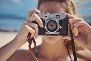 mujer con cámara analógica tomando una foto 