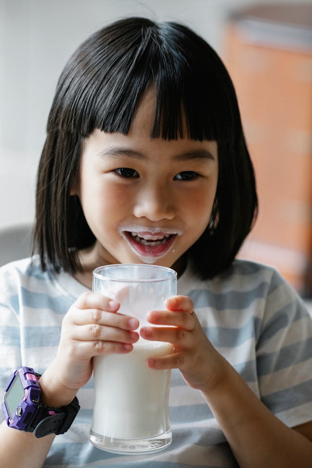 niña feliz vaso de leche