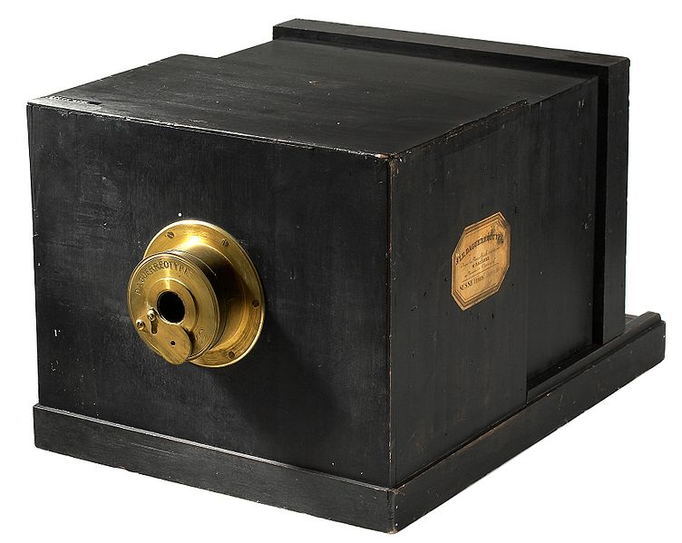 Daguerrotipo: primer aparato fotográfico de la historia. Caja de madera de color negro, con un lente que sobre sale hacia adelante, y por atrás una mirilla que permite seleccionar el encuadre a fotografiar.