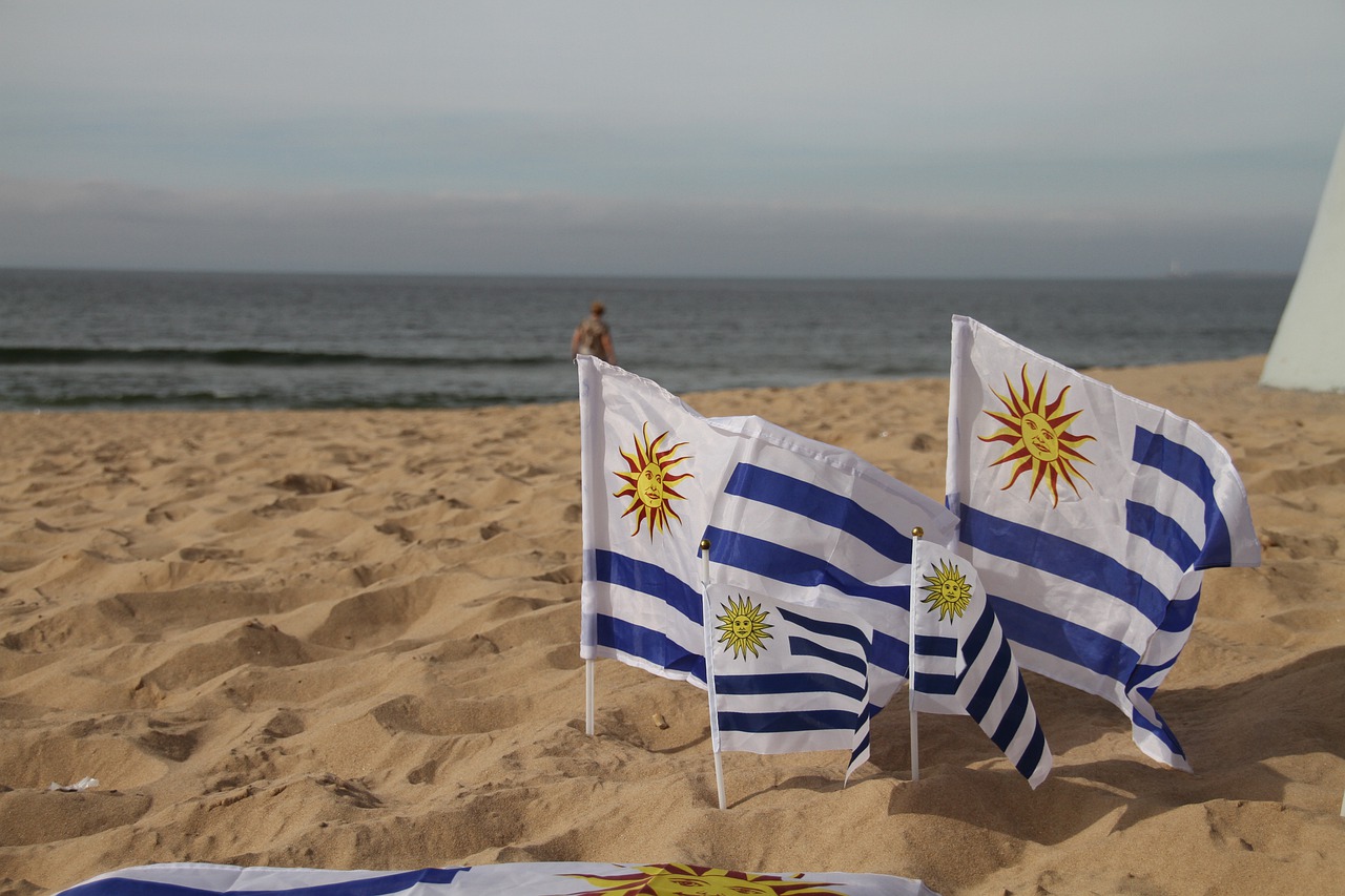 Playa con banderas de Uruguay plantadas sobre la arena