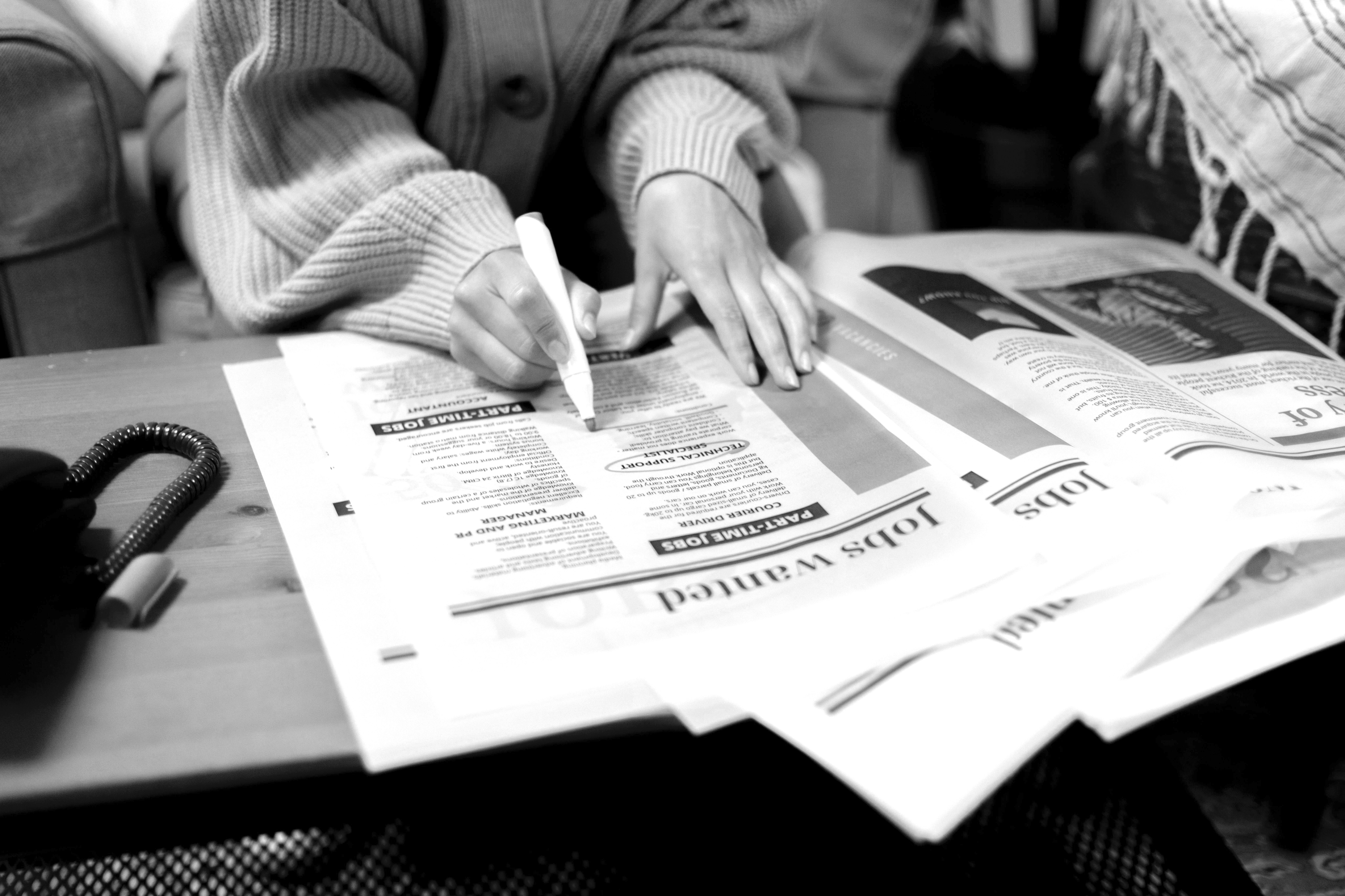 persona subrayando un periódico
