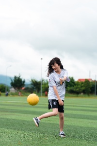 Niña jugando al fútbol.