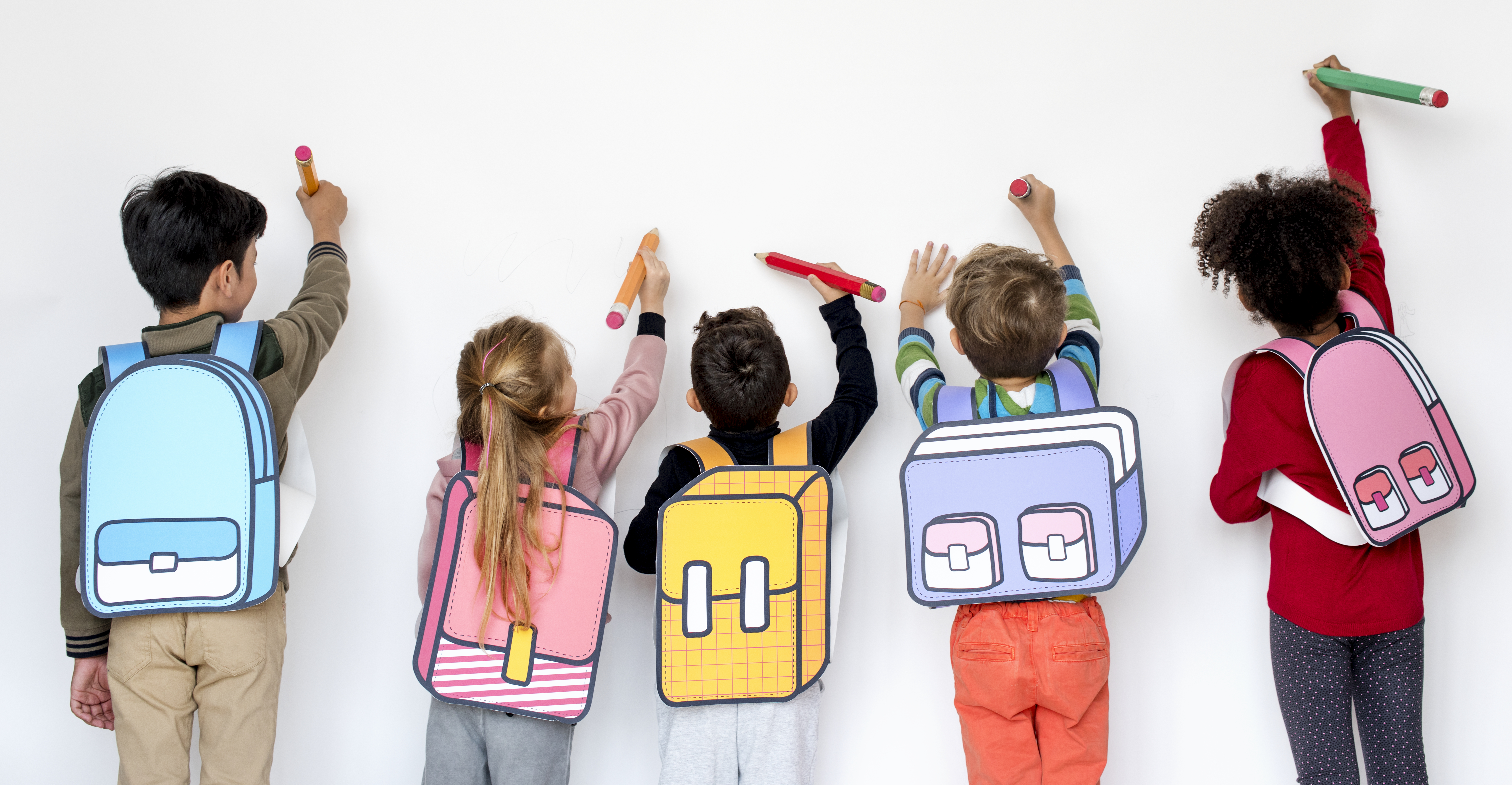 Fotografía de niños de espaldas con sus mochilas diversas