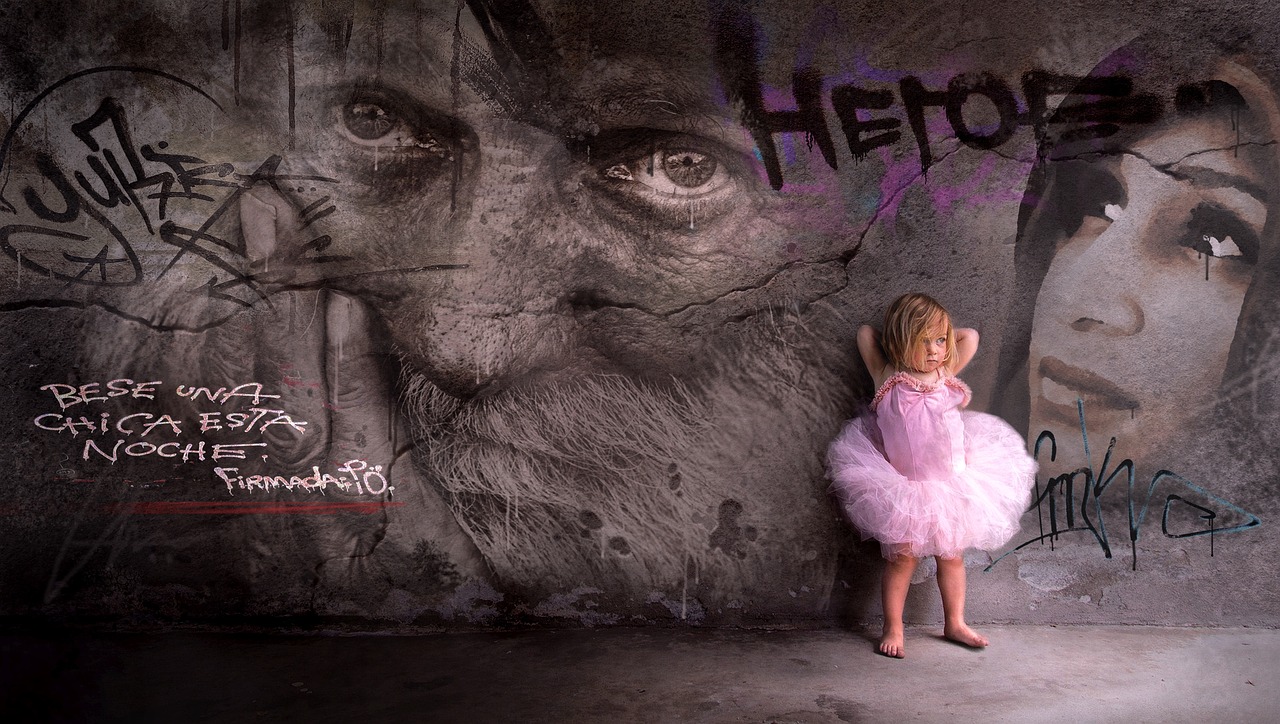 niña recostada en un muro con pinturas y palabras