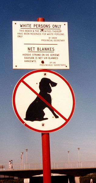 Dos carteles en una playa de Ciudad del Cabo en 1985: el letrero en inglés y en afrikaans dice que el acceso a la playa y sus instalaciones sólo es permitido a los blancos, el cartel inferior prohíbe el ingreso de perros a la playa.