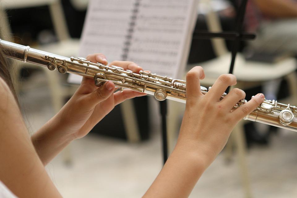 Manos de una mujer tocando flauta traversa