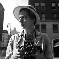 Fotografía de una mujer que se toma una fotografía frente a una vidriera